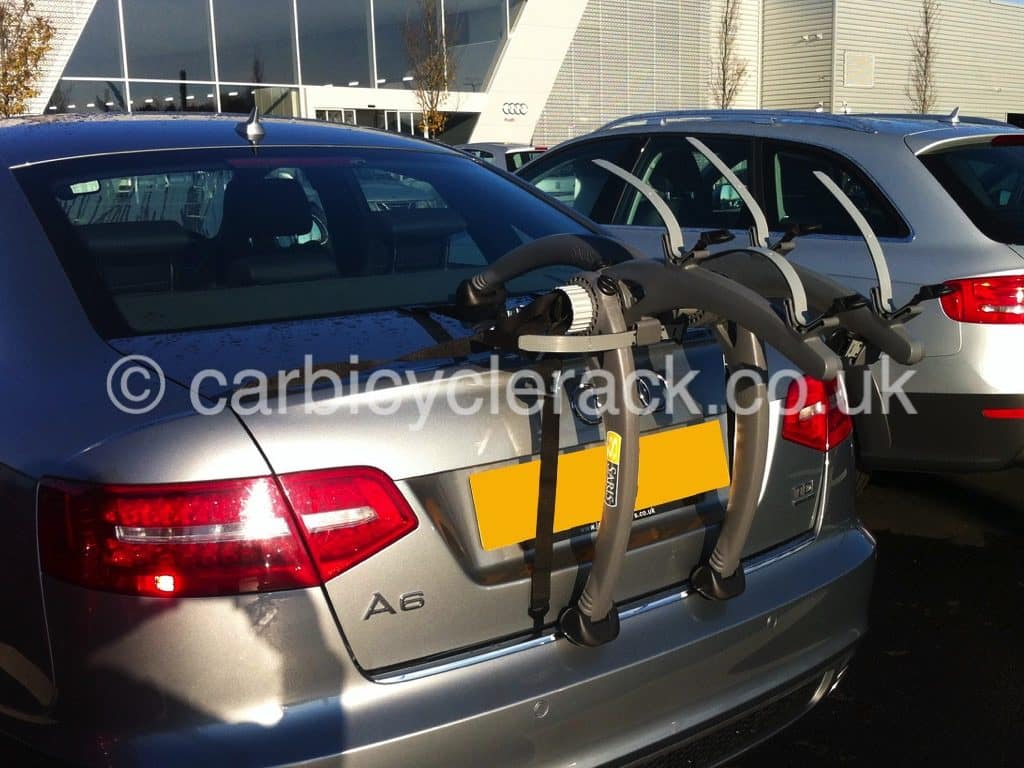 Audi A6 saloon in grey with a Bike Rack fiited outside an audi garage