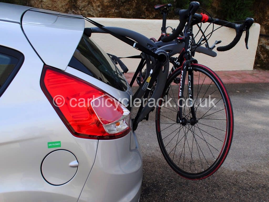 side view of a silver bmw 1 series bike rack carrying a racing bike